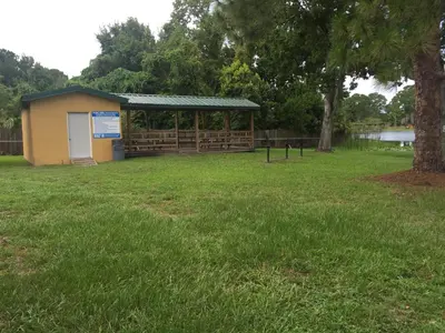 a building with a sign in a field with a tree at Budget Inn Sanford International Airport in Sanford