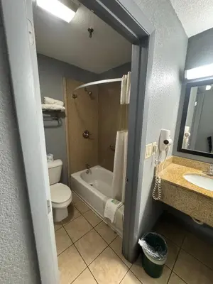 a bathroom with a tub and a toilet and a sink at Budget Inn Sanford International Airport in Sanford