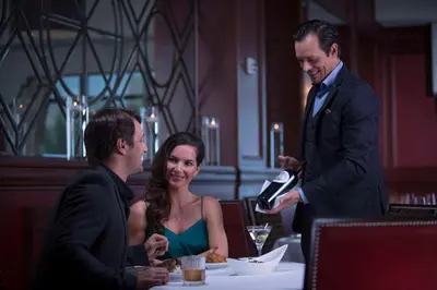 a man pouring a glass of wine to a woman at Waldorf Astoria Orlando - An Official Walt Disney World Hotel in Orlando