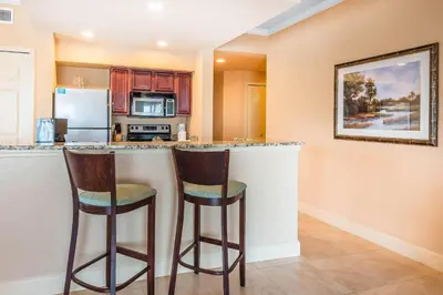 a kitchen with two bar stools at a counter at Bluegreen Vacations Fountains, an Ascend Collection Resort in Orlando