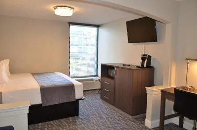a hotel room with a bed and a desk at Opal Hotel & Suites in Orlando