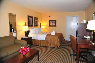 a hotel room with a bed and a desk at Opal Hotel & Suites in Orlando