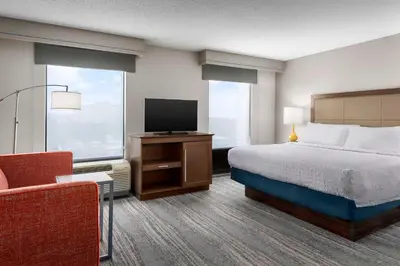 a hotel room with a bed and a tv and a chair at Hampton Inn & Suites at Lake Mary Colonial Townpark in Lake Mary