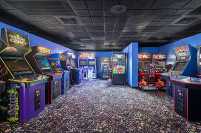 a room with arcade games and video game machines at Ramada by Wyndham Kissimmee Gateway - Free Theme Park Shuttle in Orlando