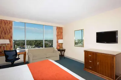 a hotel room with a bed and a television at Ramada by Wyndham Kissimmee Gateway - Free Theme Park Shuttle in Orlando