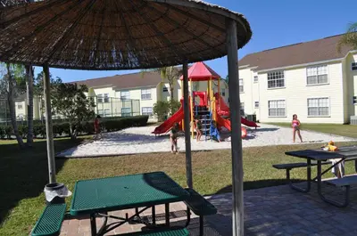 a playground with a slide and an umbrella at Villas at Laguna Bay in Kissimmee