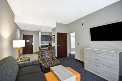 a living room with a couch and a flat screen tv at Homewood Suites by Hilton Orlando Theme Parks in Orlando