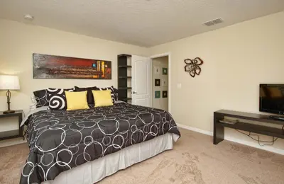 a bedroom with a bed and a flat screen tv at Family 4-Bedroom Pool Home Near Disney World in Kissimmee