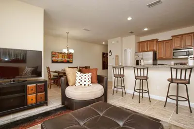 a living room with a couch and a kitchen at Family 4-Bedroom Pool Home Near Disney World in Kissimmee