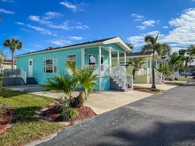 a blue house on a street with palm trees at Tropical Palms Resort in Orlando