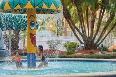 two children playing in a fountain in a swimming pool at Tropical Palms Resort in Orlando