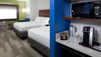 a hotel room with two beds and a tv at Holiday Inn Express & Suites Orlando At SeaWorld by IHG - With Free Shuttle Service to SeaWorld Parks in Orlando