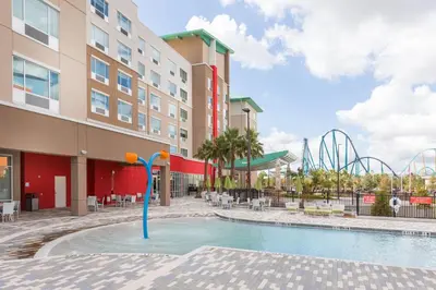 a pool at a hotel with a roller coaster at Holiday Inn Express & Suites Orlando At SeaWorld by IHG - With Free Shuttle Service to SeaWorld Parks in Orlando