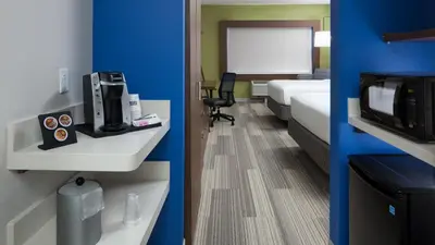 a hotel room with a bed and a microwave at Holiday Inn Express & Suites Orlando At SeaWorld by IHG - With Free Shuttle Service to SeaWorld Parks in Orlando