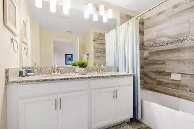 a white bathroom with a sink and a mirror at Four Bedrooms Home with Pool 3079 in Kissimmee