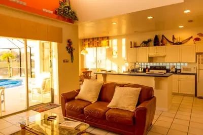 a living room with a couch and a kitchen at Suaimhneas in Kissimmee