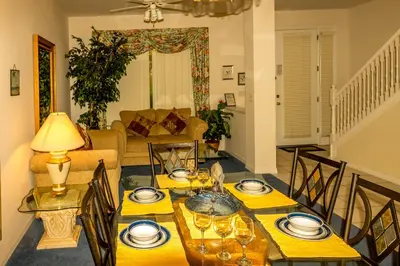 a living room with a dining table with plates and glasses at Suaimhneas in Kissimmee