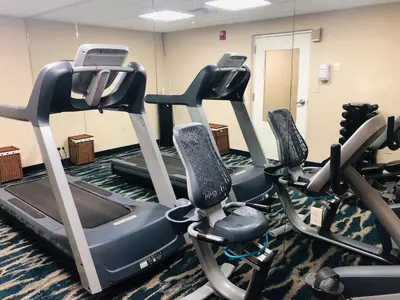 a gym with three tread machines in a room at Quality Inn & Suites Heritage Park in Kissimmee