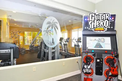 a gym with a surfboard and exercise equipment at Windsor Hills Resort 2 Miles to Disney 6-Bedroom 4-Bathrooms Villa with Private Pool and Spa in Orlando