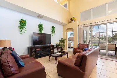 a living room with leather furniture and a flat screen tv at Windsor Hills Resort 2 Miles to Disney 6-Bedroom 4-Bathrooms Villa with Private Pool and Spa in Orlando
