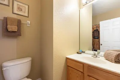 a bathroom with a toilet and a sink and a mirror at Windsor Hills Resort 2 Miles to Disney 6-Bedroom 4-Bathrooms Villa with Private Pool and Spa in Orlando