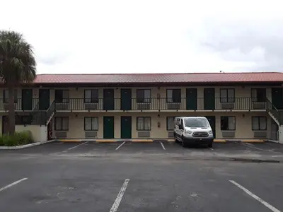 a car parked in a parking lot in front of a motel at Riviera Motel in Kissimmee