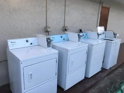 a group of white washing machines sitting next to a wall at Enterprise Motel in Kissimmee