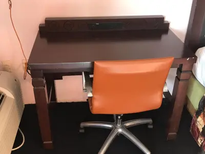 an orange chair sitting in front of a desk at Enterprise Motel in Kissimmee