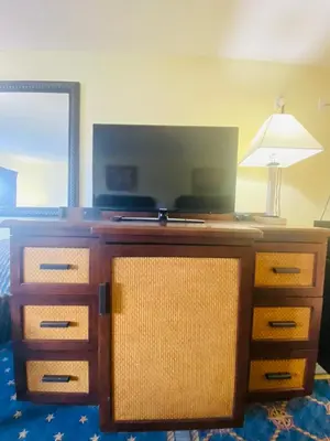 a bedroom with a dresser with a lamp on it at Maple Leaf Inn & Suites in Kissimmee