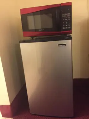 a microwave sitting on top of a refrigerator at Maple Leaf Inn & Suites in Kissimmee