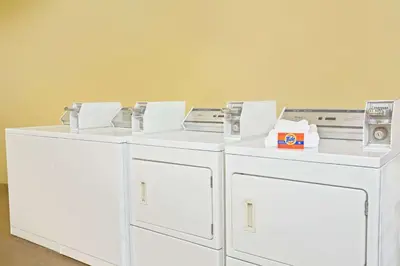 three white washing machines sitting next to each other at Days Inn by Wyndham Orlando Airport Florida Mall in Orlando
