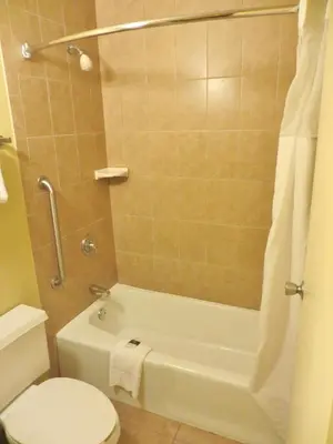 a bathroom with a tub and a toilet and a shower at Days Inn by Wyndham Orlando Airport Florida Mall in Orlando