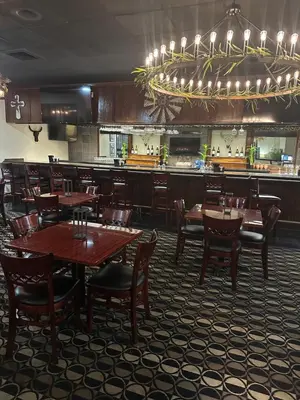 a restaurant with wooden tables and chairs and a bar at Days Inn by Wyndham Orlando Airport Florida Mall in Orlando