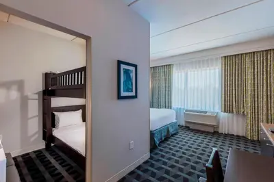 a bedroom with two bunk beds and a large window at TownePlace Suites by Marriott Orlando at SeaWorld in Orlando