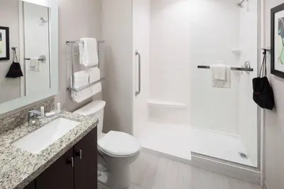a white bathroom with a toilet and a shower at TownePlace Suites by Marriott Orlando at SeaWorld in Orlando