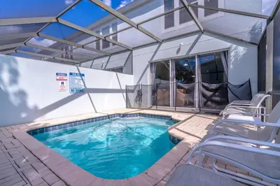 a swimming pool with chairs and a building at 2582 Windsor Hills in Orlando