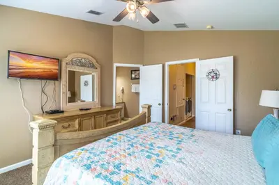 a bedroom with a bed and a dresser and a mirror at 2582 Windsor Hills in Orlando