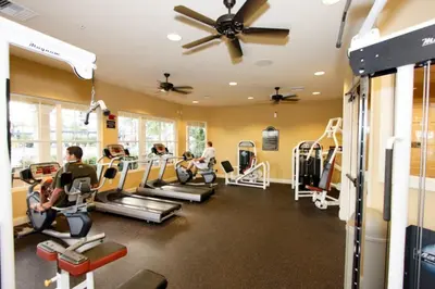 a gym with tread machines and people in it at Viz Cay 4816 in Orlando