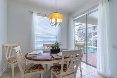 a dining room with a table and chairs and a window at 7741 Windsor Hills in Orlando