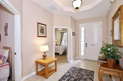 a hallway with a table and a lamp and a bedroom at 2627 Windsor Hills in Orlando