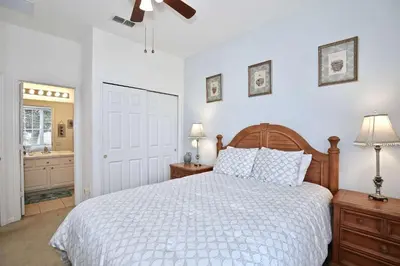 a white bedroom with a bed and a bathroom at 2627 Windsor Hills in Orlando