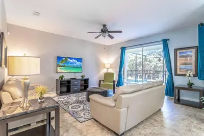 a living room with a couch and a ceiling fan at 8965 Paradise in Kissimmee