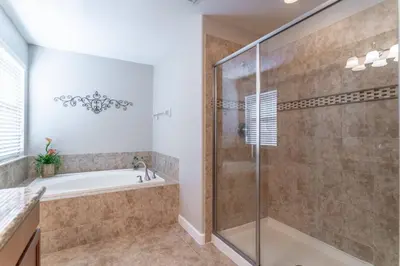 a bathroom with a tub and a shower stall at 8965 Paradise in Kissimmee