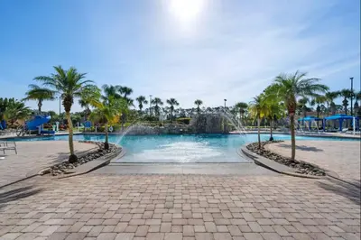 a swimming pool with palm trees and a fountain at 8965 Paradise in Kissimmee