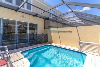 a swimming pool with a patio and a building at 7669 Windsor Hills in Orlando