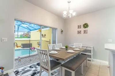 a dining room with a table and chairs and a pool at 3031 Encantada in Kissimmee
