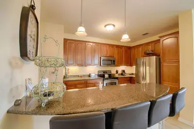 a kitchen with wooden cabinets and a large island at 5048 Viz Cay in Orlando