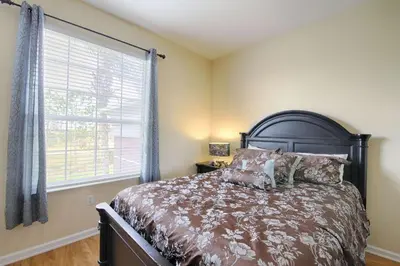 a bedroom with a large bed and a window at 5048 Viz Cay in Orlando