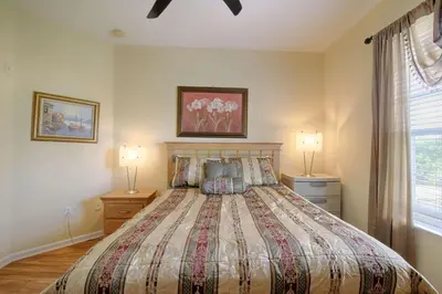 a bedroom with a large bed with two lamps at 5048 Viz Cay in Orlando