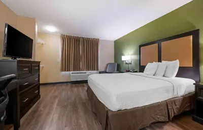 a hotel room with a bed and a flat screen tv at Extended Stay America Select Suites - Orlando - Conven Ctr - Sports Complex in Orlando